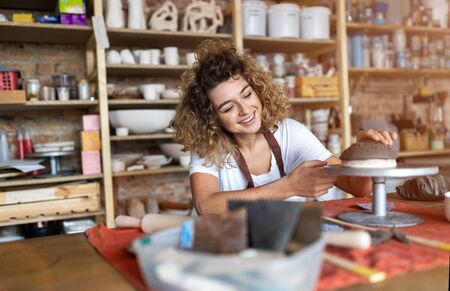 Portrait of woman pottery artist in art studio