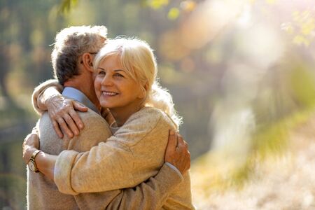 Happy senior couple in autumn parkの写真素材