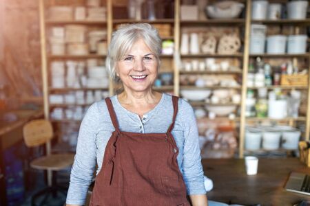 Portrait of senior female pottery artist in her art studioの写真素材