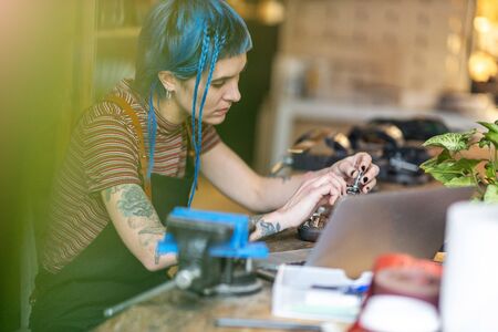 Young woman using laptop in her workshop