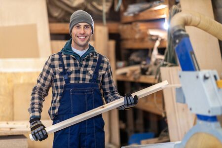 Young male worker in timber warehouse