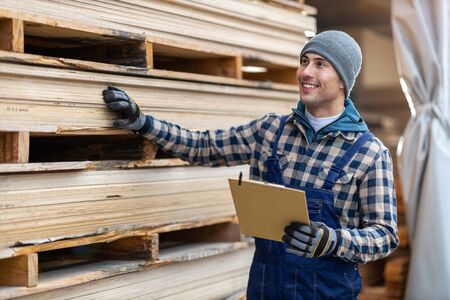 Young male worker in timber warehouseの写真素材
