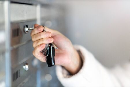 Woman unlocking apartment mailboxの写真素材