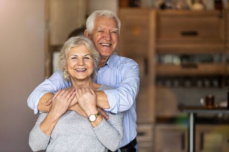 Happy senior couple embracing in their home