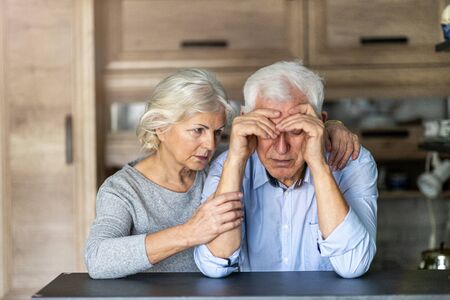Senior woman comforting her husband at homeの写真素材