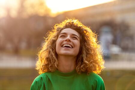 Portrait of young woman with curly hair in the cityの写真素材