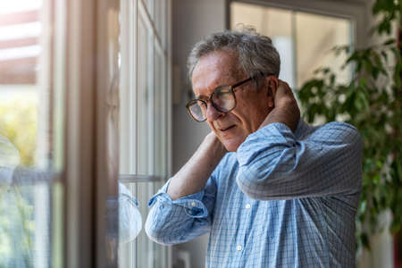 Senior man suffering from neck painの写真素材