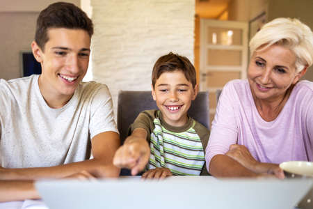 Mother with her two sons using laptop at home