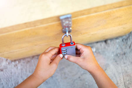Close-Up Of Child Hands Unlocking Combination Lockの写真素材