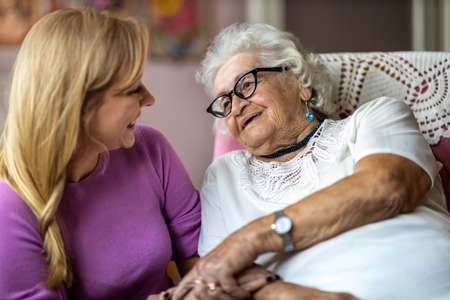 Young woman spending time with her elderly grandmother at homeの写真素材
