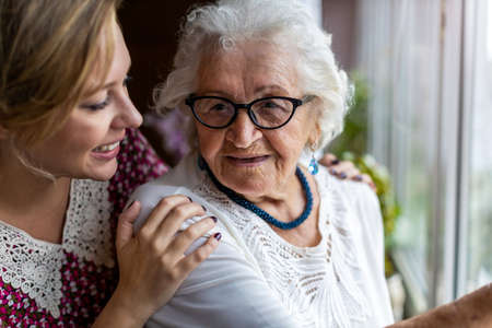 Young woman spending time with her elderly grandmother at homeの写真素材