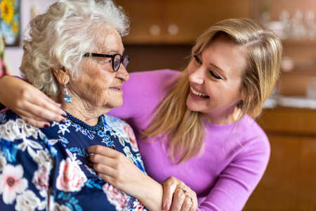 Young woman spending time with her elderly grandmother at homeの写真素材