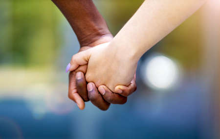 Interracial couple holding hands outdoors