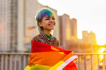 Portrait of a gender fluid person wearing rainbow flag