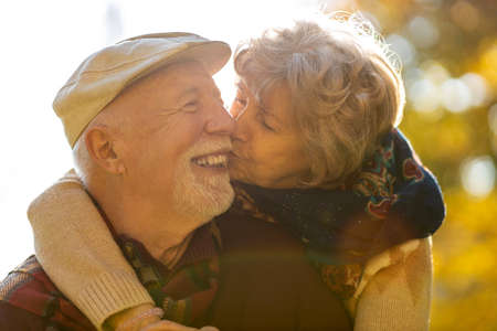 Happy senior couple spending time together in beautiful city park in autumnの写真素材