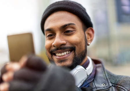 Portrait of a handsome young man using mobile phone at the streetの写真素材
