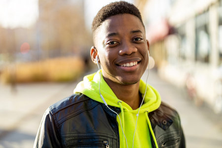 Portrait of a young man standing in a city street, smiling