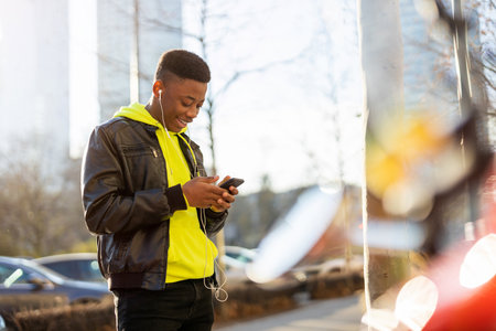 Young man using smart phone outdoors at urban setting