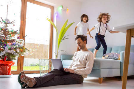 Young man working from home with his little son as a companyの写真素材