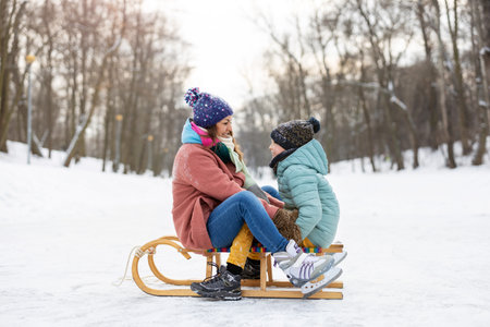 Mother and son having a great winter day outdoors playing in the snowの写真素材