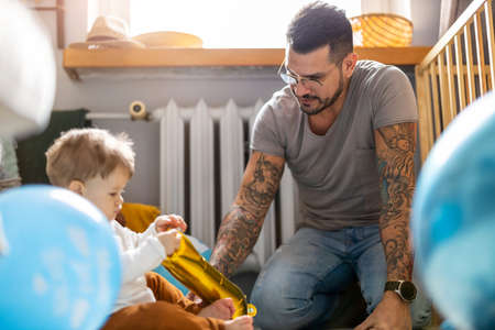 Father and baby son having fun together at homeの写真素材