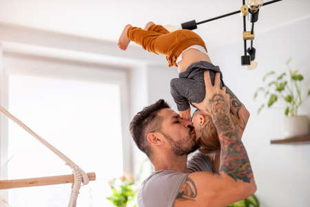 Father playing with his little son at homeの写真素材