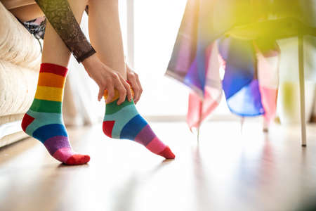 Close-up of a person putting on rainbow socksの写真素材