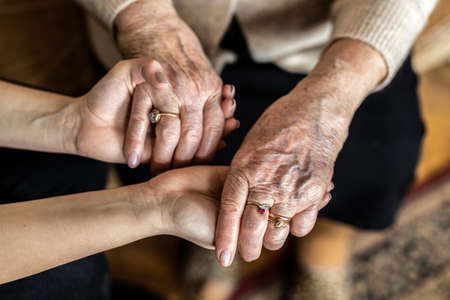 Cropped shot of a senior woman holding hands with a nurseの写真素材