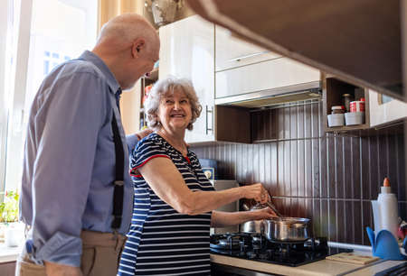 Senior couple together in their kitchen at homeの写真素材