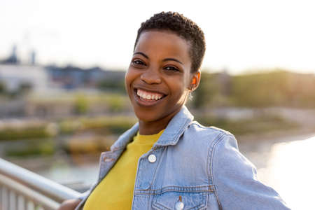 Smiling young woman enjoying the outdoors at sunset