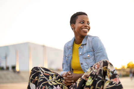 Smiling young woman enjoying the outdoors at sunsetの写真素材
