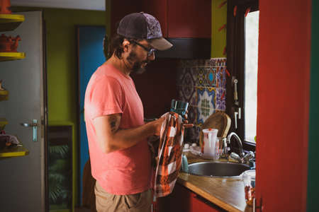 Man washing dishes at homeの写真素材