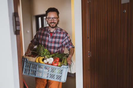 Man delivering fruit and vegetable boxの写真素材
