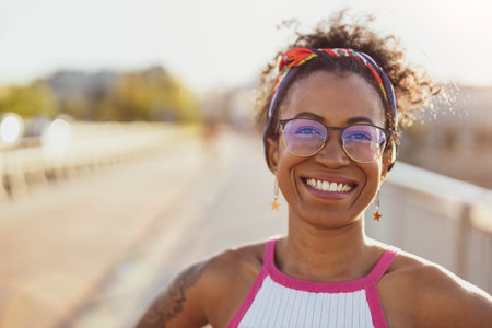 Portrait of young woman smiling outdoors at sunsetの写真素材