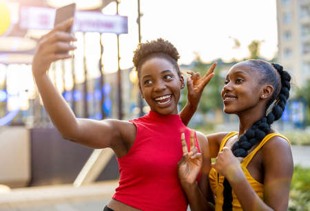 Happy girlfriends taking a selfie together outdoorsの写真素材