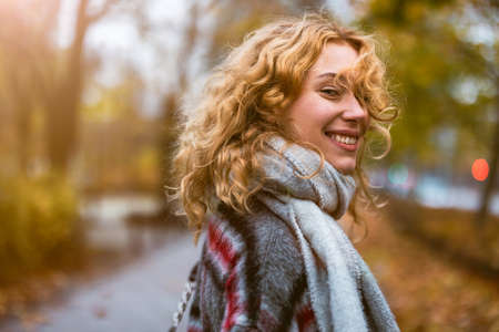 Happy young woman in autumn parkの写真素材