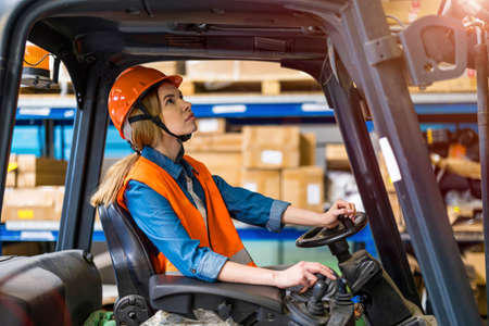 Young female forklift driver working in a warehouseの写真素材