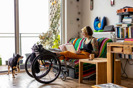 Young woman with disability with her dog at home