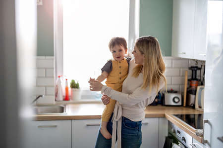 Mother playing with her little son at homeの写真素材