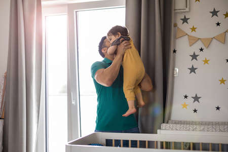 Dad playing with his little son at home
