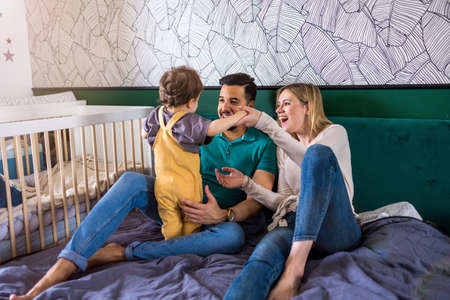 Young parents playing with their child at home
