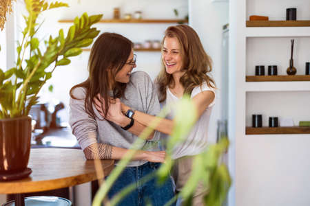 Portrait of affectionate lesbian couple embracing at home