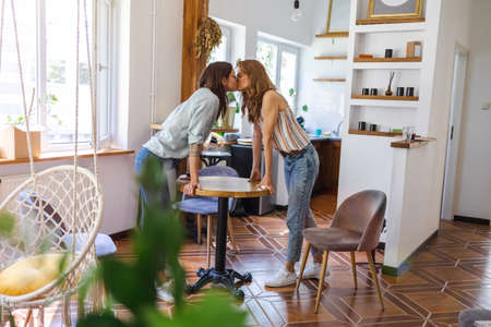 Lesbian couple kissing in their home