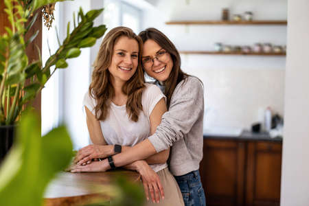 Portrait of affectionate lesbian couple embracing at homeの写真素材