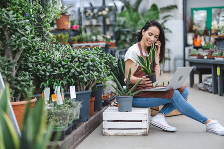 Garden center worker using laptopの写真素材