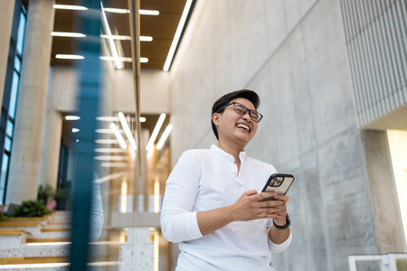 Smiling young man using mobile phoneの写真素材