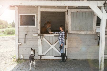Young woman in a stable with her horseの写真素材