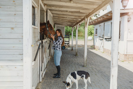 Young woman in a stable with her horseの写真素材