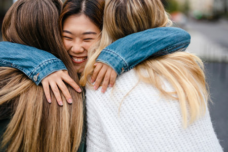 Three female friends hugging each otherの写真素材