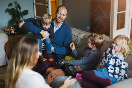 Happy young family having good time together at homeの写真素材